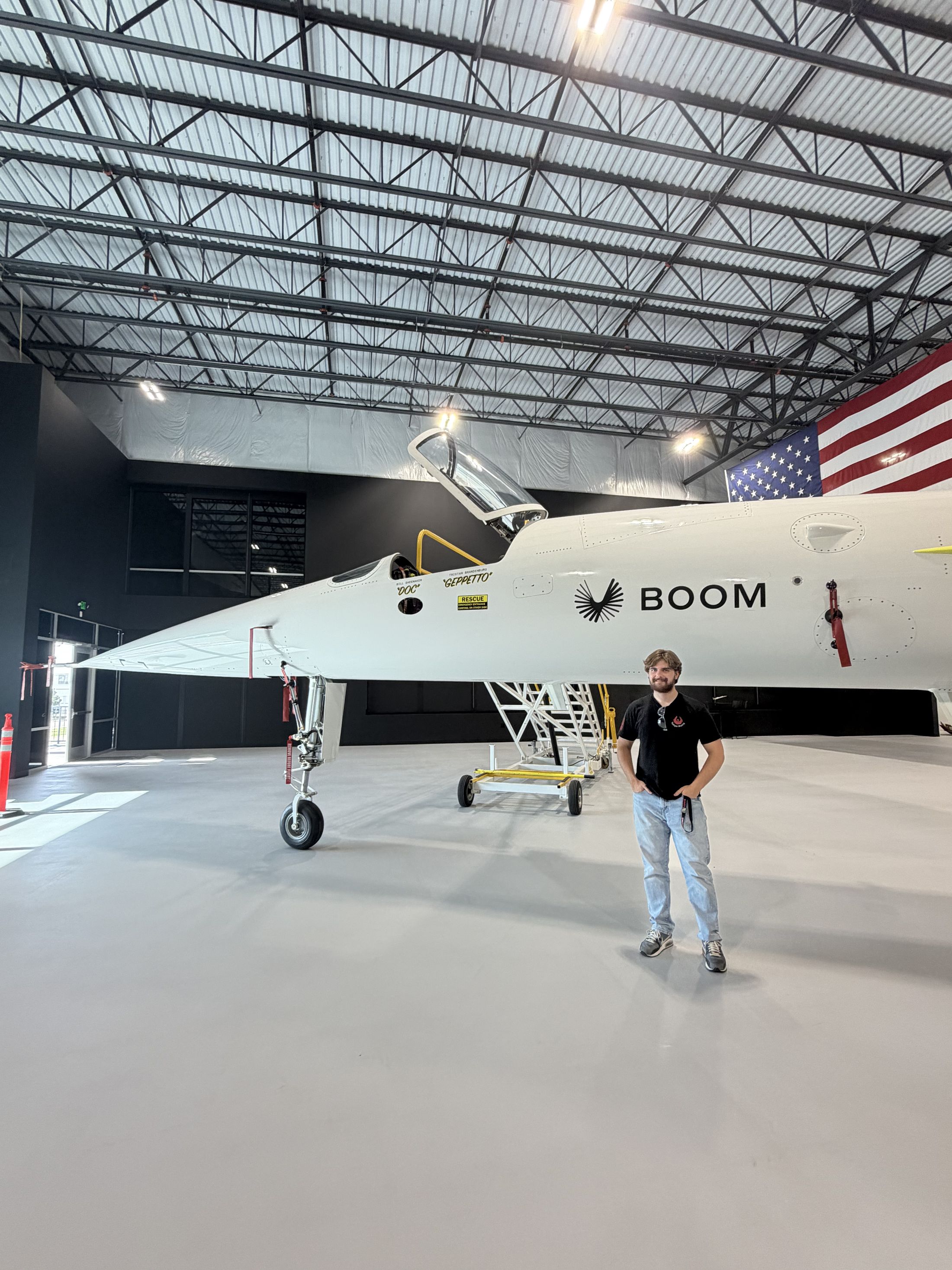 Jeffrey Buskirk in front of a Boom Supersonic aircraft in the hangar